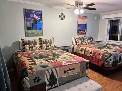 a bedroom with two beds and a ceiling fan at Rangeley Town & Lake in Rangeley