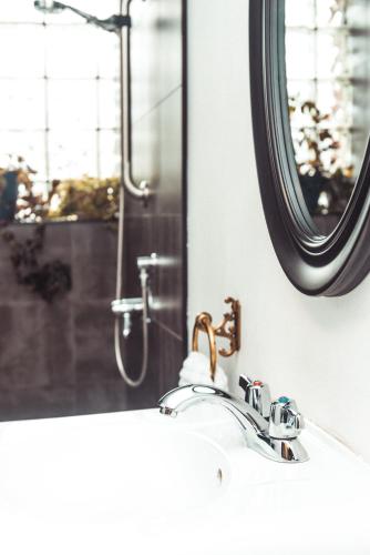 a bathroom sink with a mirror and a shower at The Haven Hostel in Thunder Bay