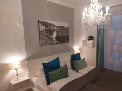 Schlafzimmer mit einem Bett mit blauen und grünen Kissen in der Unterkunft Grenzberg Appartements in Bad Gastein