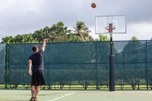a man playing basketball on a tennis court at The Cliffs at Princeville in Princeville