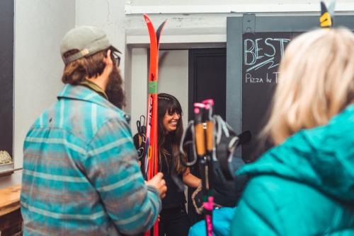 a group of people standing in a room with skis at The Haven Hostel in Thunder Bay