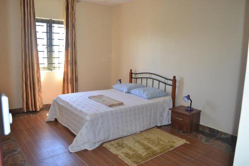 1 dormitorio con cama, mesa y ventana en Apartment is calm locality, en Flic en Flac