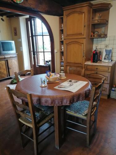 una cocina con una mesa de madera con sillas alrededor. en Sam Bott, en Chambon-sur-Voueize