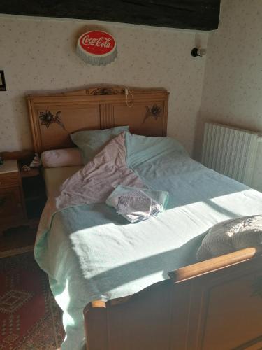 a bed in a bedroom with a cocacola sign on the wall at Sam Bott in Chambon-sur-Voueize