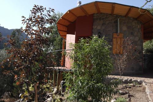 a small building with a wooden door in a garden at Tres Continentes in San José de Maipo