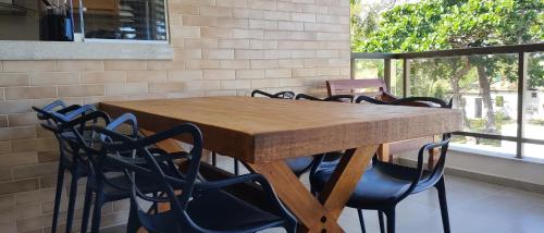 a wooden table with chairs around it in a kitchen at Itacimirim Apartments Ondas in Itacimirim