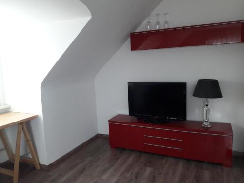 a living room with a television on a red dresser at Appartement 34 in Schwäbisch Hall