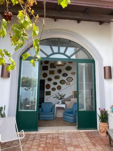 a green door with two blue chairs in a building at Villa San Francesco in Massa Lubrense