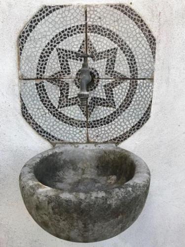 a stone water fountain in the side of a building at Villa San Francesco in Massa Lubrense