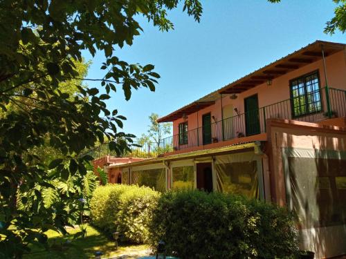 a house with green shutters and a balcony at Posada Don Salvador in San Antonio de Areco