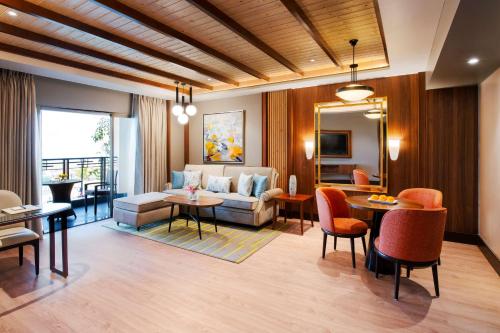 Radisson Blu Resort Dharamshala في دارامشالا: غرفة معيشة مع أريكة وطاولة