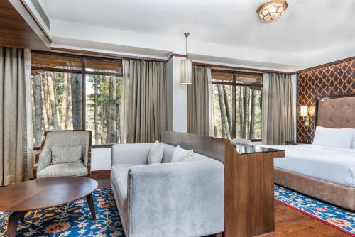 a hotel room with a bed and a couch at Radisson Golf Resort Pahalgam in Pahalgām