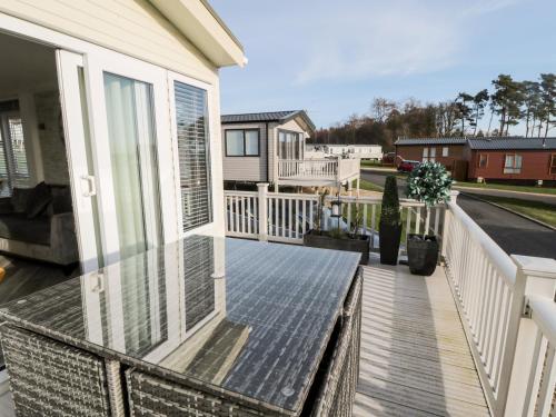 a balcony with glass doors and a table at 23 Valley View in Morpeth