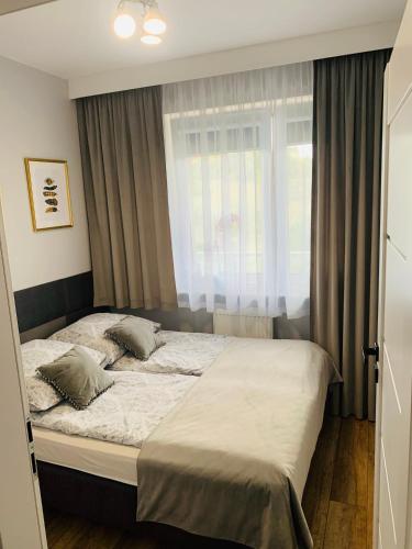 a bedroom with a large bed with a window at Apartament Stemar z dyżym baloknem in Gorzów Wielkopolski