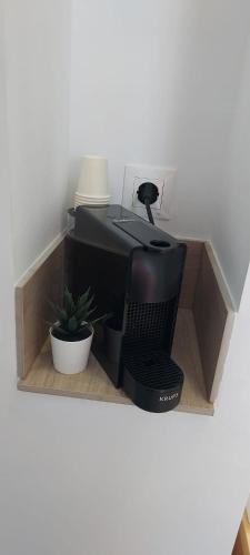 a computer monitor sitting on a shelf with a plant at La Mongeta Màgica. in Castellón de la Plana