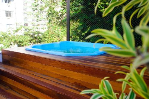 a hot tub on a wooden deck with plants at Hotel Village Icaraí in Niterói
