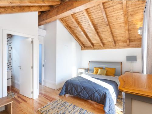 1 dormitorio con cama y techo de madera en Castle Beach House, en Leça da Palmeira