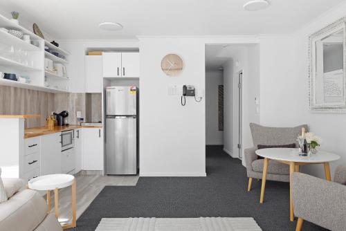 a kitchen and living room with a stainless steel refrigerator at 123 Landmark in Nelson Bay