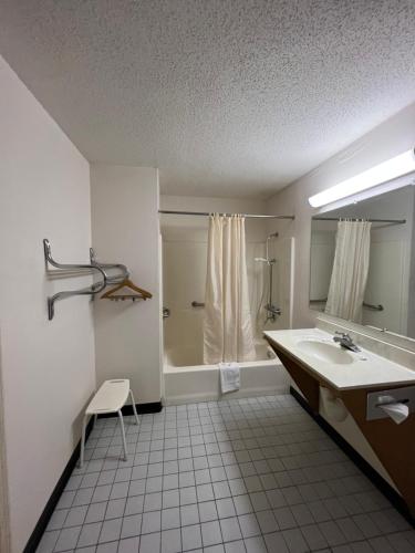 uma casa de banho branca com um lavatório e um chuveiro em Garden Inn & Suites em Metter