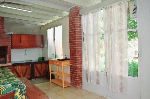 eine Küche mit Ziegelwand und Fenster in der Unterkunft Dona Monica in Ituzaingó