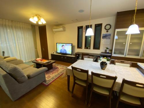 a living room with a table and a couch at 花沢民宿 in Odawara