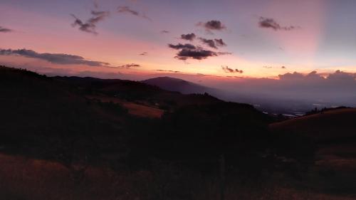 a sunset over a hill with a mountain at Altos de Quiluva in Suesca