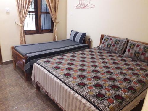 a bedroom with two beds and a window at Naaval Beach Villa & Rooms in Batticaloa