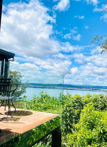 a glass balcony with a view of a lake at Acacia Cliffs Lodge in Taupo