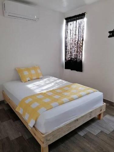 a bed sitting in a room with a window at Black & White casa privada con alberca in Monterrey