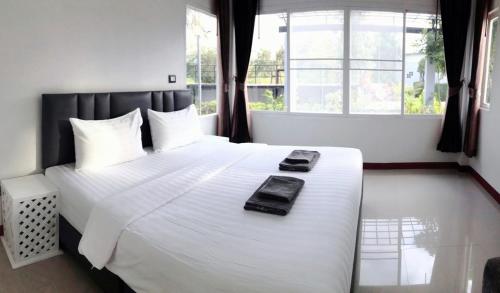 猜也奔的住宿－Park Villa Chaiyaphume，卧室配有一张带白色床单的大床和窗户。