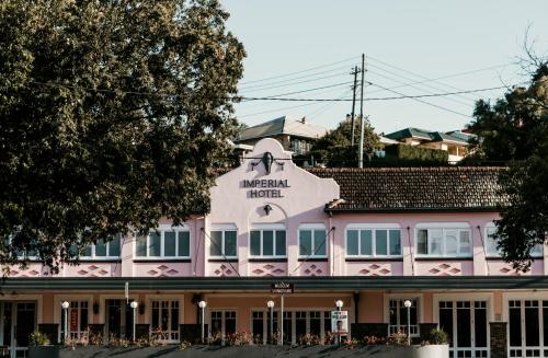 a pink building with a sign that reads american hotel at The Imperial Hotel in Murwillumbah