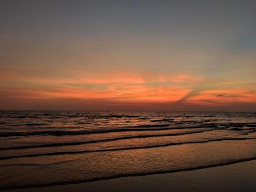 a sunset on the beach with the ocean at The Narima - SHA Plus in Ko Lanta