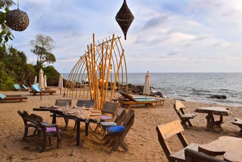 a group of tables and chairs on a beach at The Narima - SHA Plus in Ko Lanta