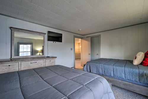 a bedroom with a bed and a mirror and a television at Family-Friendly Retreat Walk to Lake George! in Lake George