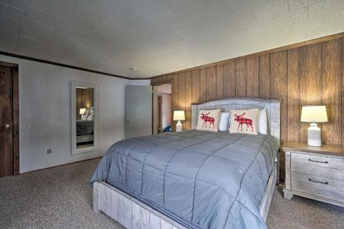a bedroom with a large bed and wooden walls at Family-Friendly Retreat Walk to Lake George! in Lake George