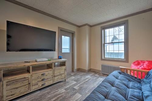 a living room with a large flat screen tv at Family-Friendly Retreat Walk to Lake George! in Lake George