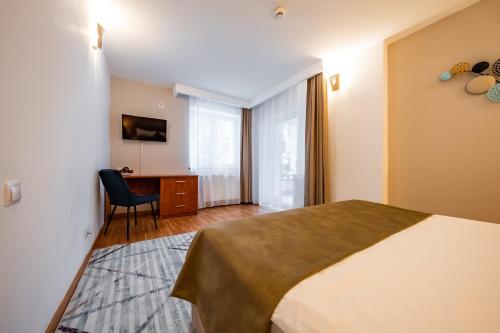 a bedroom with a bed and a desk with a chair at Vila Diana - Poiana Brasov with breakfast optional at hotel Simona Halep in Poiana Brasov