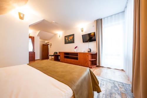 a bedroom with a bed and a flat screen tv at Vila Diana - Poiana Brasov with breakfast optional at hotel Simona Halep in Poiana Brasov