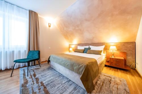 a hotel room with a bed and a chair at Vila Diana - Poiana Brasov with breakfast optional at hotel Simona Halep in Poiana Brasov