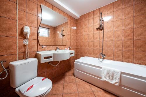 y baño con aseo, bañera y lavamanos. en Vila Diana - Poiana Brasov, en Poiana Brasov