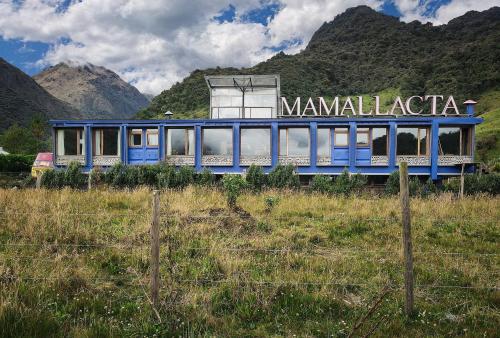 a blue train in a field with mountains in the background at Mamallacta Páramo Lodge in Papallacta