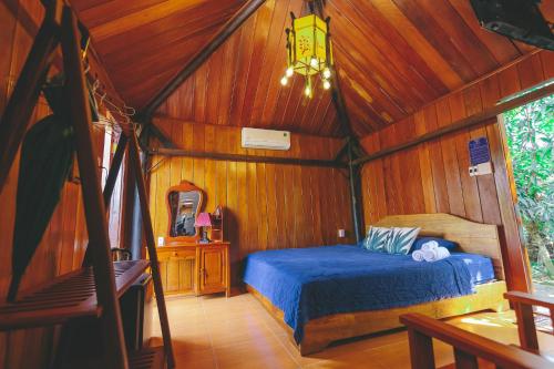 芹苴的住宿－CASA ECO Mekong Homestay，木制客房内的一间卧室,配有一张床