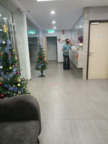 Un árbol de Navidad en un vestíbulo con una persona en una tienda. en MORNINGS HOTEL, en Sungai Petani