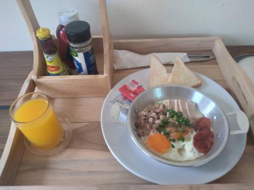Una lonchera con un tazón de comida y un vaso de jugo de naranja en Park Villa Chaiyaphume, en Chaiyaphum