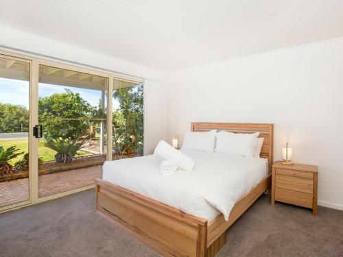 a bedroom with a bed and a large window at Peppertree Jervis Bay Pet Friendly Beachfront with Sea Views in Callala Beach