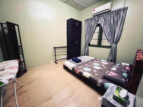a bedroom with a bed and a chair in it at Arni Homestay - Geliga in Cukai