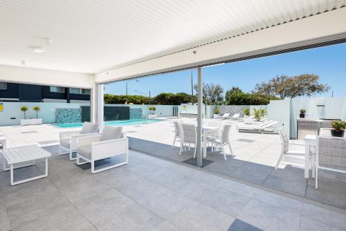 an outdoor patio with white furniture and a pool at The Waterford on Main Beach in Gold Coast