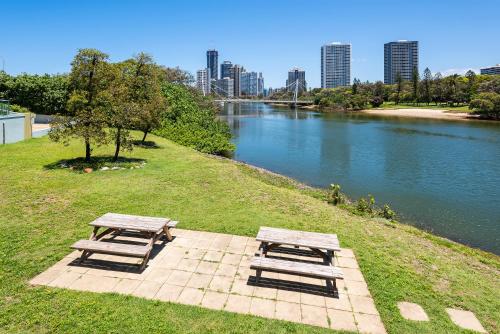 two picnic tables on a field next to a river at The Waterford on Main Beach in Gold Coast