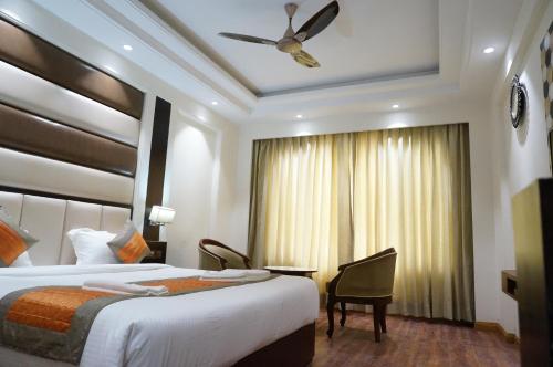 a hotel room with two beds and a window at Hotel Grand palace in Bahraich