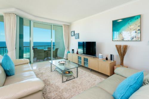 a living room with a couch and a television at The Waterford on Main Beach in Gold Coast